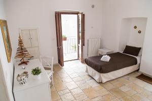 ラテルツァにあるL'Angolo del Marcheseのベッドルーム1室(ベッド1台付)、バルコニーへのドアが備わります。