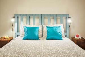 um quarto com uma cama com almofadas azuis em Casa da Sobreira em Sobral de São Miguel