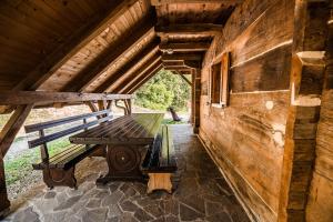a wooden bench sitting on the porch of a cabin at Sleme house in Krška Vas