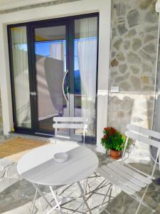 un tavolo bianco e 2 sedie su un patio di Collimare Rooms & Sailing near 5 Terre a Vezzano Ligure