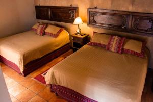1 dormitorio con 2 camas y una lámpara en una mesa en All Suite El Marques de Antigua en Antigua Guatemala