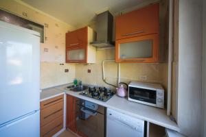 a small kitchen with a sink and a microwave at Flat on Dneprovsky boulevard in Mogilev