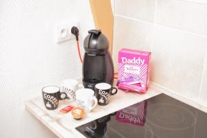 a coffee maker sitting on a shelf with coffee cups at APPARTEMENT DU CENTRE in Charleville-Mézières