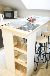 a kitchen island with stools and a counter top at APPARTEMENT DU CENTRE in Charleville-Mézières