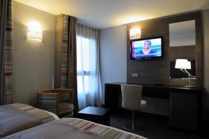 a hotel room with a bed and a desk and a television at Holiday Inn Paris Montmartre by IHG in Paris