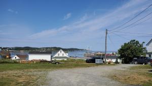 a house with a car parked next to a street at Hillside Cottage 1 in Twillingate