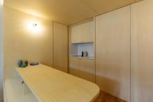 une petite cuisine avec une table en bois et des placards dans l'établissement Oporto Historial Centre - Studio T0, à Porto
