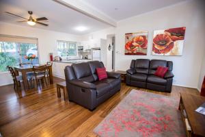 a living room with two leather chairs and a table at Mt Cotton Retreat in Mount Cotton