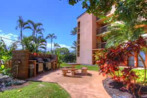 um pátio com uma mesa de piquenique em frente a um edifício em Maui Vista 1313 em Kihei