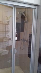 baño con ducha y puerta de cristal en La Muscadîne, en Le Loroux-Bottereau