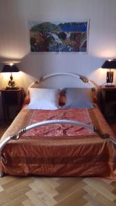 1 cama grande en un dormitorio con 2 lámparas en La Muscadîne, en Le Loroux-Bottereau