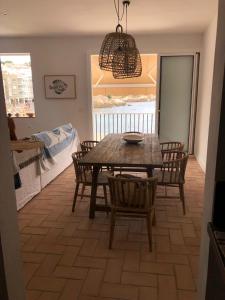 a dining room with a wooden table and chairs at Can Nicasi in L'Escala