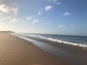 a beach with footprints in the sand and the ocean at Atlantic Waves Accommodation in Carcavelos