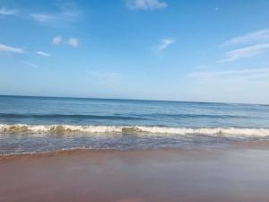 a beach with the ocean and a few waves at Atlantic Waves Accommodation in Carcavelos