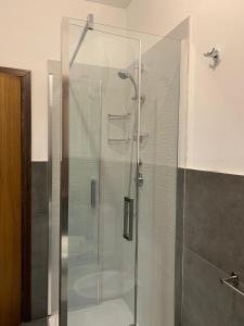 a shower with a glass door in a bathroom at Blue Wood Apartment in Letojanni