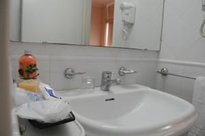 y baño con lavabo blanco y espejo. en Parra Hotel & Suites en Rafaela