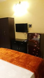 a bedroom with a bed and a flat screen tv at C Pearl in Majorda