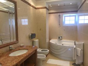 a bathroom with a tub and a toilet and a sink at Atlantic Waves Accommodation in Carcavelos