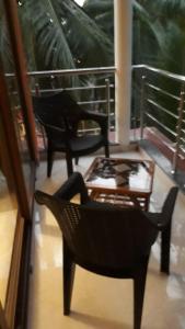 a room with two chairs and a table on a balcony at C Pearl in Majorda