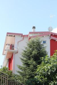 een rood-wit gebouw met een boom ervoor bij B&B D'Amare in San Salvo