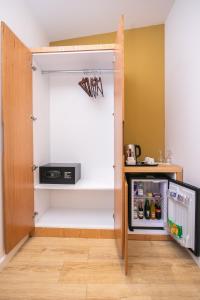 einen Schrank mit einer offenen Tür und einem Kühlschrank in der Unterkunft Hotel Elior in Tirana