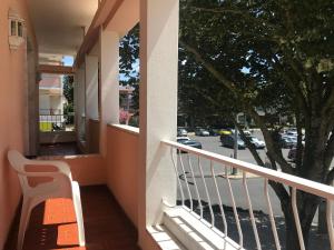 a balcony with a bench and a view of a street at Atlantic Waves Accommodation in Carcavelos