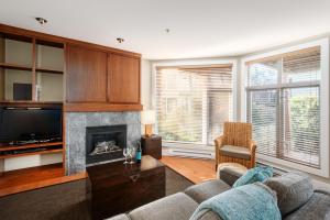 - un salon avec un canapé et une cheminée dans l'établissement Cox Bay Beach Resort, à Tofino