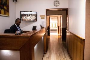 a man sitting at a bar in a room at Hotel Carolina Montecarlo in Quito