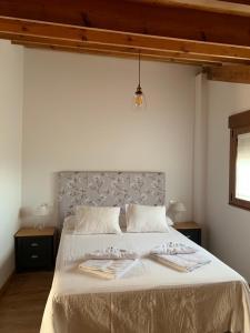 een slaapkamer met een groot bed en 2 handdoeken bij La casa de Lucas y Alex in Ponferrada