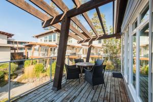 a patio with a table and chairs on a deck at Cox Bay Beach Resort in Tofino