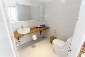 a bathroom with a sink and a toilet and a mirror at Peppercorn Beach Resort in Phú Quốc