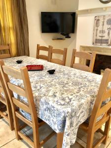 een eetkamer met een tafel en stoelen en een televisie bij Lauras Townhouse Apartments Lansdown Slope Townhouse in Bath