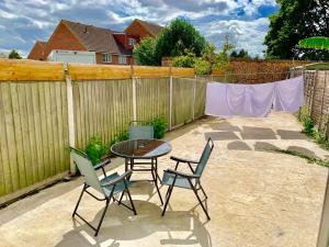 un patio con mesa, sillas y una valla en 3 Bedrooms, 3 Baths, Spacious Lounge, Full Kitchen, Garden, Ground Floor, Free Parking, en Londres