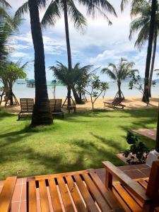 a park with benches and palm trees on the beach at Peppercorn Beach Resort in Phú Quốc