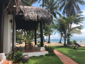 a house with a porch with a view of the beach at Peppercorn Beach Resort in Phú Quốc