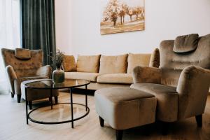 a living room with a couch and chairs and a table at ZEN Central Apartments in Cluj-Napoca
