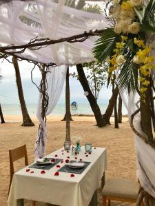 a table on the beach with a white table cloth at Peppercorn Beach Resort in Phú Quốc
