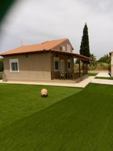 a house with a yard with a ball on the grass at Villa ARETOUSA - Cretan Hospitality in Protória