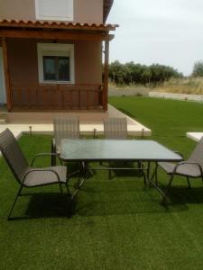 a picnic table and chairs on a lawn at Villa ARETOUSA - Cretan Hospitality in Protória