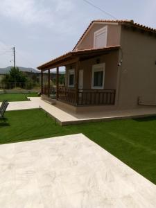 a house with a large patio and a yard at Villa ARETOUSA - Cretan Hospitality in Protória