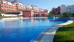 duży basen z niebieską wodą przed budynkami w obiekcie Apartamento Ayamonte golf Costa Esuri w mieście Ayamonte