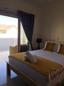 a bedroom with a large bed with a large window at Laksmi Guest House in Canggu