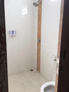 a bathroom with a shower with a toilet and a sink at Laksmi Guest House in Canggu