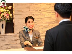 a woman sitting at a table talking to a man at Richmond Hotel Namba Daikokucho in Osaka