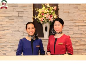 two women standing next to each other in front of a wall at Richmond Hotel Namba Daikokucho in Osaka