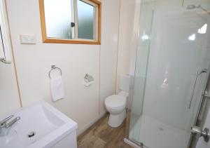 a bathroom with a toilet and a glass shower at Beauty Point Tourist Park in Beauty Point +37 photos