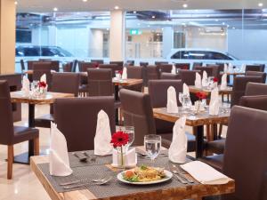 a restaurant with tables and chairs with a plate of food at Nevada Ketapang Hotel in Ketapang