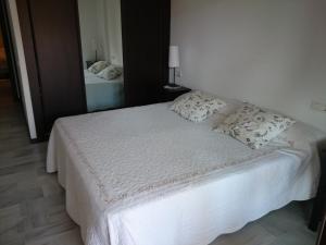 sypialnia z białym łóżkiem z poduszkami w obiekcie Apartamento Ayamonte golf Costa Esuri w mieście Ayamonte