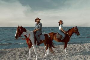 a man and woman riding horses on the beach at Tunis Village Chalet in Fayoum