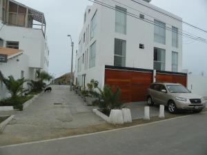 un coche aparcado en un aparcamiento al lado de un edificio en Departamentos en Playa La Isla, en Punta Hermosa